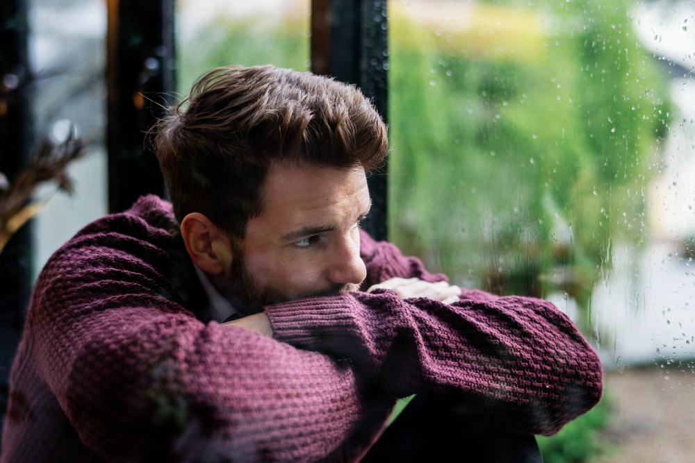 thoughtful-man-looking-out-window